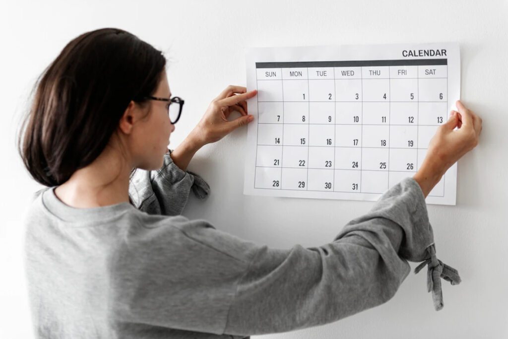 девушка вешает календарь 