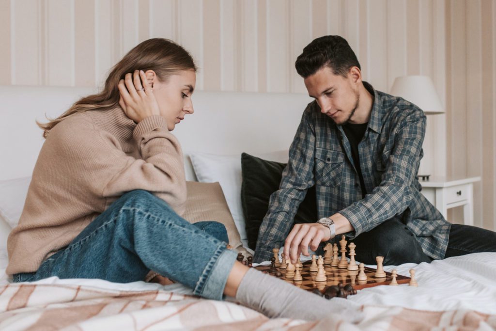 мужчина и девушка играют в шахматы